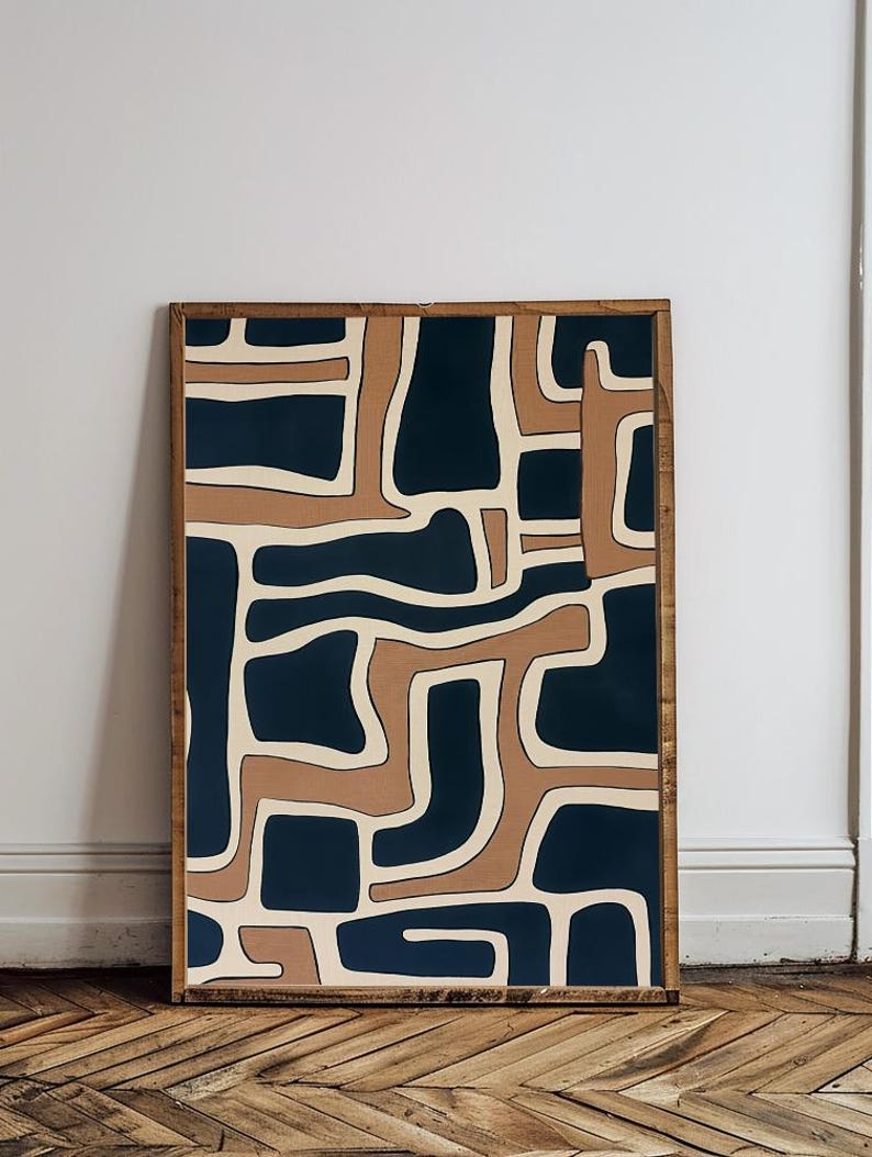 May include: Abstract art print with a geometric pattern in shades of brown, beige, and navy blue. The print is framed in a natural wood frame.