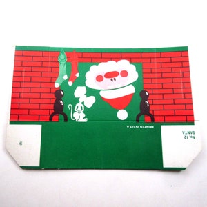 Boîte de bonbons de Noël en carton inutilisée vintage avec le père Noël à l'envers dans une cheminée