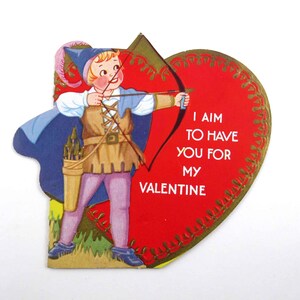 May include: Vintage Valentine's Day card featuring a cartoon archer aiming a bow and arrow. The archer wears a blue hat, cape, and tunic, with pink pants. A red heart with gold trim and the text "I AIM TO HAVE YOU FOR MY VALENTINE" completes the design.
