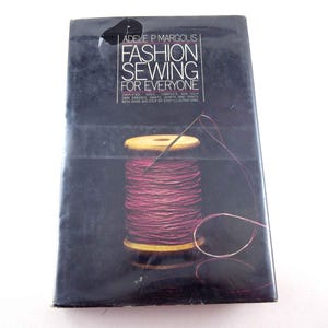 May include: A book titled "Fashion Sewing for Everyone" by Adele P. Margolis. The cover features a spool of pink thread with a needle threaded through it.