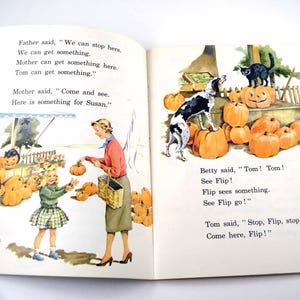 May include: An open vintage children's book with two pages showing illustrations of a pumpkin patch. The left page shows a child and adult with a basket, and the right page shows a dog and a black cat on pumpkins. Text includes dialogue.