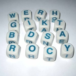 May include: A collection of white letter dice with teal blue letters. The dice are scattered across a white surface. The letters on the dice spell out various words, perfect for word games.