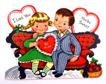 Carte de Saint-Valentin vintage pour enfants avec une petite fille et un garçon mignons sur le canapé avec des pommes en coeur