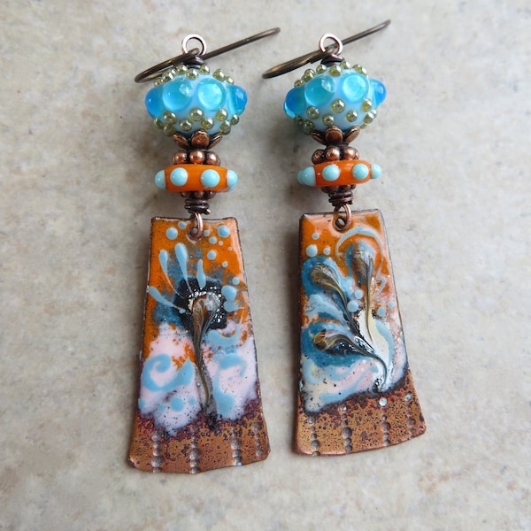 Les opposés s'attirent... Boucles d'oreilles artisanales en cuivre émaillé et verre au chalumeau. Boucles d'oreilles bleues et orange florales bohèmes artisanales.