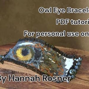 Op de afbeelding: Een kralenarmband met een uilenoogontwerp. De armband heeft een geel en bruin oogpatroon, met zwarte en zilveren kralen. De tekst "Owl Eye Bracelet PDF tutorial" en "By Hannah Rosner" zijn zichtbaar.