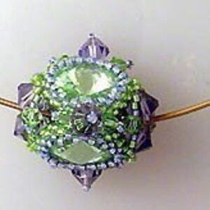 K&ouml;nnte beinhalten: Ein gr&uuml;ner und violetter Perlenanh&auml;nger mit einer goldenen Kette. Der Anh&auml;nger ist eine Kugel mit einem facettierten Design.