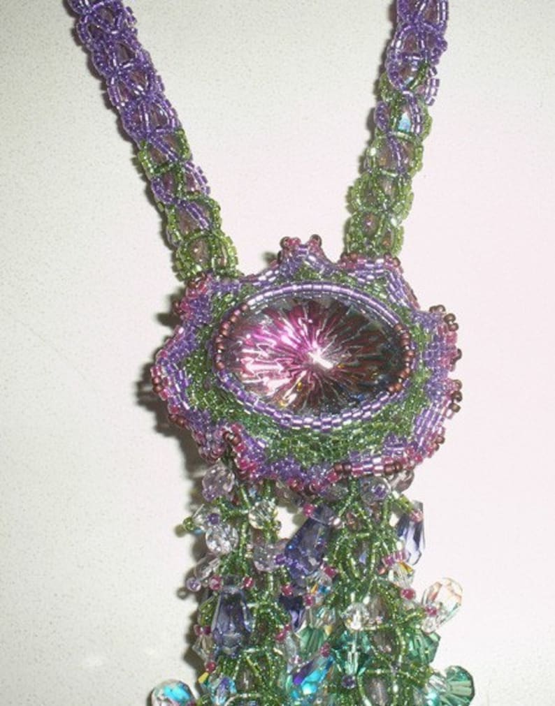 May include: A handmade beaded necklace featuring a large, oval-shaped pendant with a central iridescent stone. The necklace incorporates shades of purple, green, and clear beads, creating a detailed and ornate design. The necklace is a unique piece of jewelry.