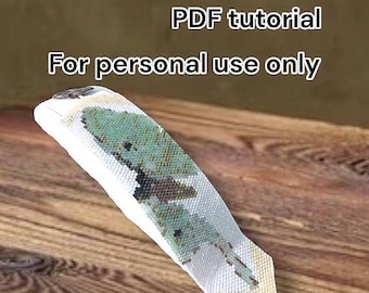 May include: A white and green Luna Moth bracelet, with a PDF tutorial, is displayed on a wooden surface. The text on the image reads "Luna Moth Bracelet PDF tutorial For personal use only By Hannah Rosner."
