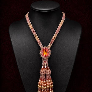 May include: A beaded lariat necklace with a large orange gemstone pendant and a tassel. The necklace is displayed on a black mannequin. The text "Garden Passions Lariat Necklace" and "PDF Tutorial" are visible.