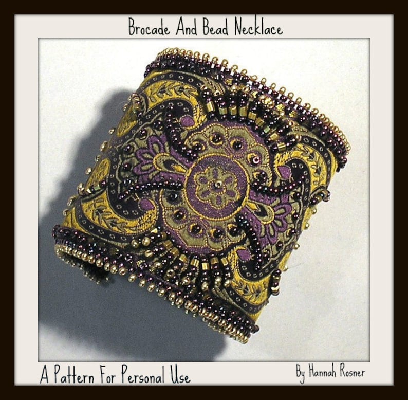 May include: A close-up of a gold and purple brocade and bead necklace. The necklace is made of a patterned fabric with gold and purple beads sewn around the edges. The text "Brocade And Bead Necklace" is at the top of the image. The text "A Pattern For Personal Use" is at the bottom left of the image. The text "By Hannah Rosner" is at the bottom right of the image.
