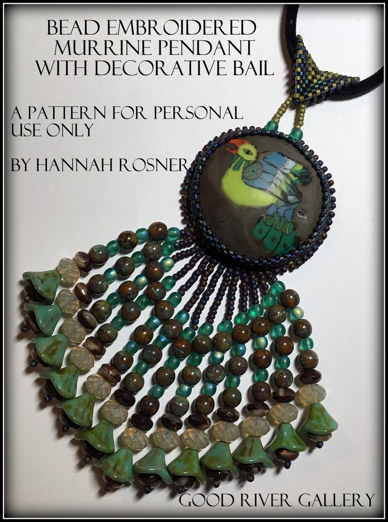K&ouml;nnte beinhalten: Ein Perlenanh&auml;nger mit einer bunten Murrine-Glasperle als Mittelpunkt, einer dekorativen &Ouml;se und einer Fransen aus gr&uuml;nen, braunen und klaren Perlen. Der Anh&auml;nger ist mit "BEAD EMBROIDERED MURRINE PENDANT WITH DECORATIVE BAIL" und "A PATTERN FOR PERSONAL USE ONLY BY HANNAH ROSNER" beschriftet.