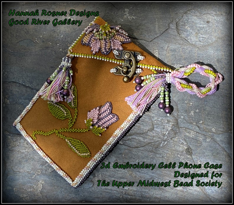 May include: A brown leather cell phone case with a 3D beaded floral design. The case has a clasp closure and a beaded tassel. The text "3d Embroidery Cell Phone Case Designed for The Upper Midwest Bead Society" is printed on the case.