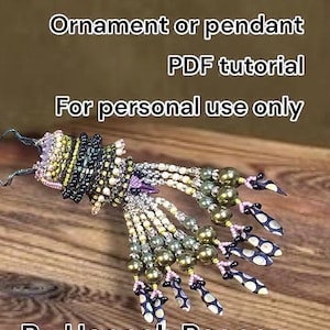 Peut inclure: Ornement ou pendentif en forme d'urne grecque en perles. Le design présente diverses couleurs de perles, dont le vert, le noir, le blanc et le violet. Le texte sur l'image indique "Grecian Urn Ornament or pendant PDF tutorial For personal use only By Hannah Rosner."