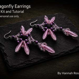 May include: A pair of dragonfly earrings with a full kit and tutorial. The earrings feature a delicate design with pink, translucent wings and purple beads. The text "Dragonfly Earrings" and "By Hannah Rosner" are visible.