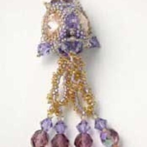 K&ouml;nnte beinhalten: Eine Perlenkette mit einem Anh&auml;nger in Form einer violetten und goldenen Blume und einem herabh&auml;ngenden Kristalltropfen. Der Anh&auml;nger ist aus Perlen gefertigt und hat eine perlmuttartige Mitte.
