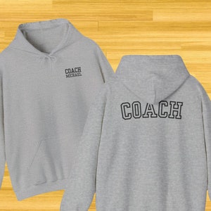 May include: Gray hooded sweatshirt with the word "COACH" printed in black on the back and "COACH MICHAEL" printed in black on the front.