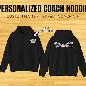 May include: Black hoodie with the text "PERSONALIZED COACH HOODIE" at the top. The front of the hoodie has "COACH JEFF" printed in white. The back of the hoodie has "COACH" printed in white. The text "CUSTOM NAME + PERFECT COACH GIFT" is also visible.