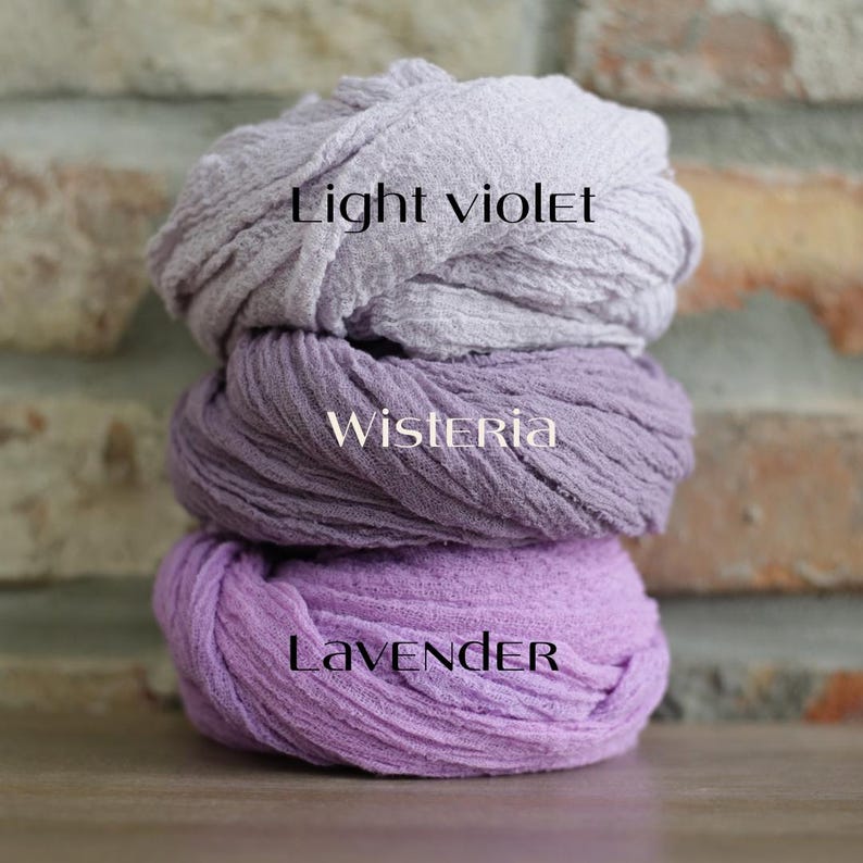 K&ouml;nnte beinhalten: Ein Stapel aus drei strukturierten Stofft&uuml;chern in verschiedenen Violettt&ouml;nen. Das oberste Tuch ist mit Light violet, das mittlere mit Wisteria und das unterste mit Lavender beschriftet. Jeder Stoff weist eine geknitterte, gazeartige Textur auf.