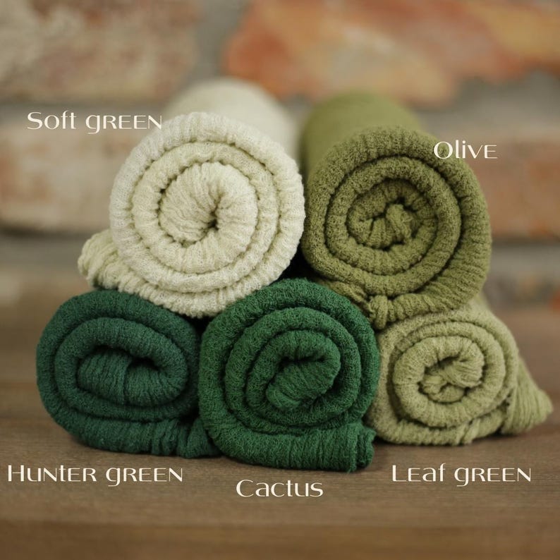 K&ouml;nnte beinhalten: F&uuml;nf gerollte Stoffmuster in verschiedenen Gr&uuml;nt&ouml;nen. Die Farben sind als Soft Green, Olive, Hunter Green, Cactus und Leaf Green beschriftet. Jedes Stoffst&uuml;ck weist eine texturierte, gerippte Oberfl&auml;che auf und ist in einem Stapel angeordnet.