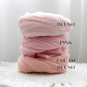 K&ouml;nnte beinhalten: Ein Stapel aus drei strukturierten Stofft&uuml;chern in verschiedenen Rosat&ouml;nen. Das oberste Tuch ist mit BLUSH beschriftet, das mittlere mit PINK und das untere mit CREAM BLUSH. Jedes Stoffst&uuml;ck weist eine geknitterte, leichtgewichtige Optik auf.