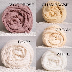 K&ouml;nnte beinhalten: F&uuml;nf Rollen aus strukturiertem Stoff, angeordnet in einem Raster. Die Farben sind beschriftet als Woodrose, ein staubiges Rosa; Champagne, ein blasses Gold; Cream, ein warmes Off-White; Ivory, ein sanftes helles Beige; und White, ein helles Neutral.