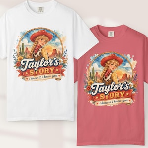 Op de afbeelding: Een wit t-shirt en een koraalroze t-shirt, beide met een afbeelding van een cowgirl met een rode hoed, woestijnlandschap en bloemen. De tekst luidt Taylor's STORY en i knew it i knew you, omlijst door een touwontwerp met sterren en hartjes.