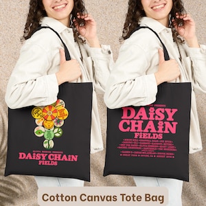 Könnte beinhalten: Eine schwarze Tragetasche aus Baumwoll-Canvas mit einem Grafikdruck aus bunten runden Abzeichen und dem Text Olivia Rodrigo Presents Daisy Chain Fields. Die Rückseite zeigt den Text Daisy Chain Fields in Pink mit einer Liste von Künstlern.