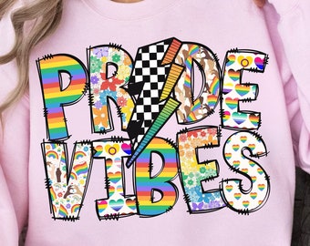May include: Pink sweatshirt with the text "PRIDE VIBES" in rainbow colors and a patchwork design. The text is outlined in black and has a lightning bolt in the middle.