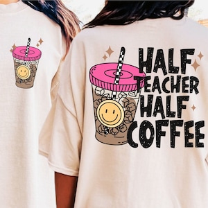 Op de afbeelding: Een beige T-shirt met een afbeelding van een koffiebeker met een smiley-gezicht en de tekst "HALF TEACHER HALF COFFEE" gedrukt op de achterkant.
