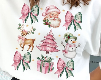 May include: White sweatshirt featuring a festive Christmas design. The design includes Santa Claus, a reindeer, a snowman, a Christmas tree, gift boxes, and bows in pink and green. Gold stars accent the design.