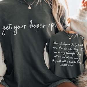 May include: A dark gray sweatshirt with the text "get your hopes up." printed in white. The sweatshirt also features a quote from Isaiah 40:31 in white text.
