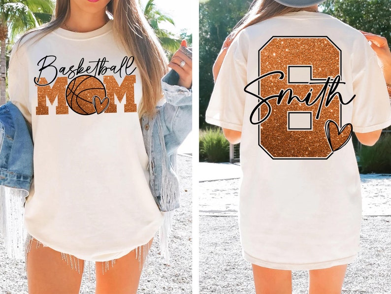 May include: White t-shirt with a gold glitter basketball and the text "Basketball Mom" on the front. The back of the shirt has a gold glitter number 8 with the text "Smith" and a small heart.