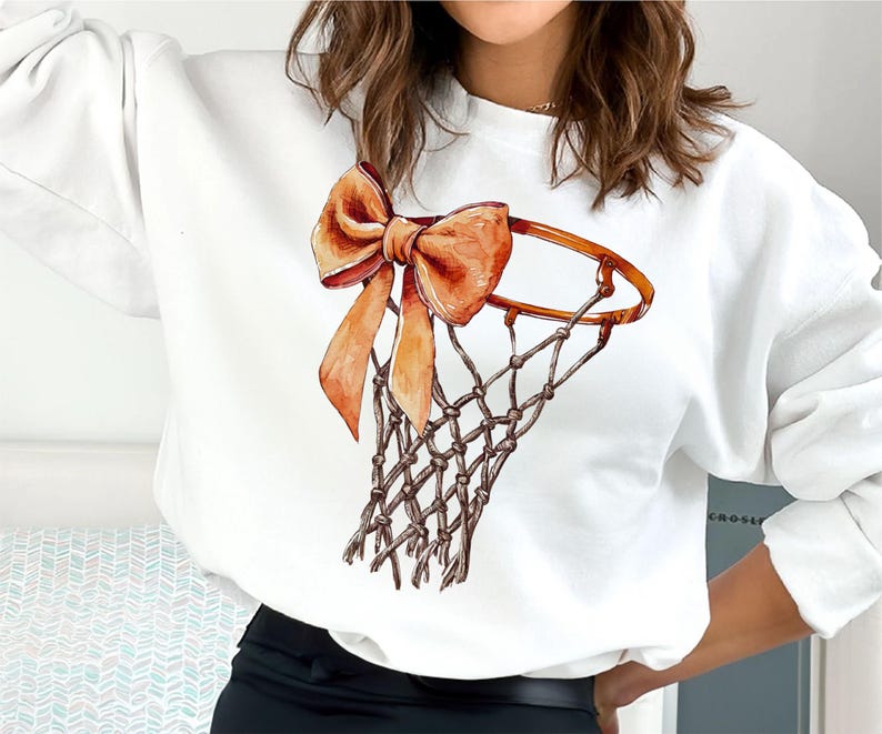 Op de afbeelding: Witte trui met een afbeelding van een basketbalring met een oranje strik.