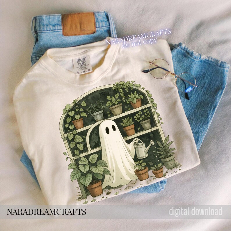 K&ouml;nnte beinhalten: Cremefarbenes T-Shirt mit einer skurrilen Illustration eines Geistes, der Pflanzen in einem Gew&auml;chshaus gie&szlig;t. Das Design umfasst Topfpflanzen, eine Gie&szlig;kanne und den Text "NARADREAMCRAFTS do not copy". Das Shirt wird mit hellblauen Jeans kombiniert.