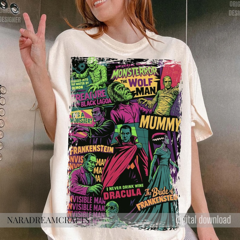 May include: Cream-colored t-shirt featuring a colorful collage of classic Universal Monsters. The design includes images of the Creature from the Black Lagoon, Wolfman, Mummy, Frankenstein, Dracula, and the Invisible Man. Text includes "Monsteror", "Mummy", and "Bride of Frankenstein".