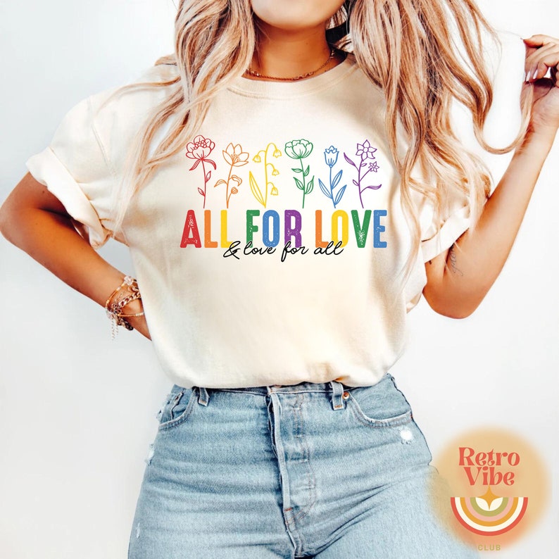 Puede incluir: Una camiseta blanca con un dise&ntilde;o de arco&iacute;ris de flores y el texto "ALL FOR LOVE & love for all".