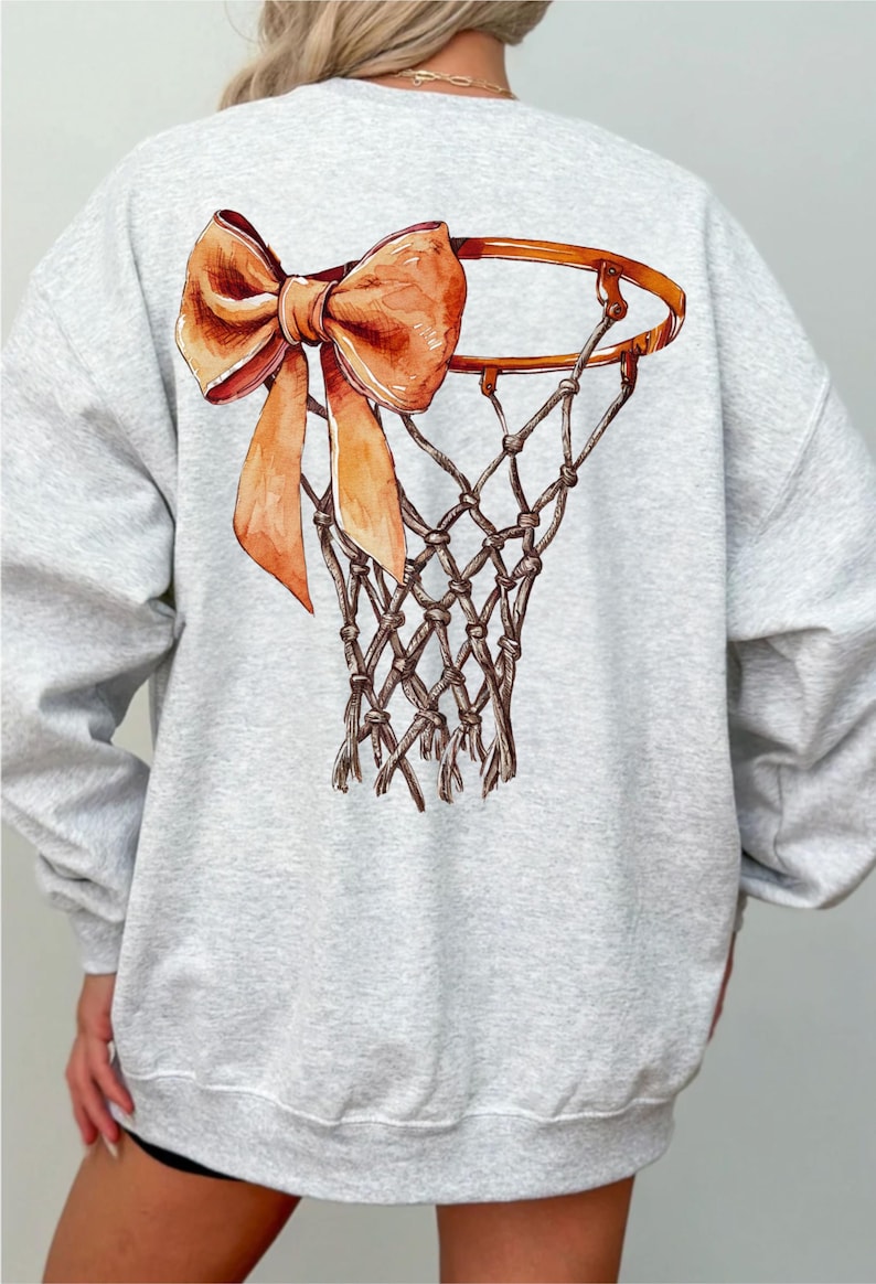 Op de afbeelding: Een grijs sweatshirt met een basketbalring en een grote oranje strik op de rug.