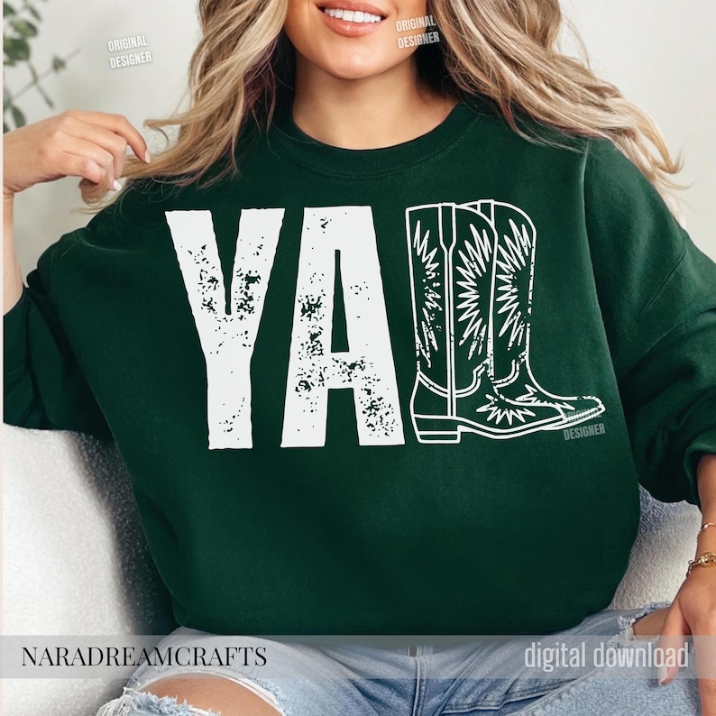 May include: Dark green sweatshirt with the word "YA" in distressed white letters and a white outline of cowboy boots. The text "NARADREAMCRAFTS" is at the bottom.