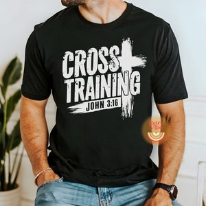 May include: Black t-shirt with the white text "CROSS TRAINING" and "JOHN 3:16" in a distressed font. A white cross graphic is behind the text. The shirt is a crew neck style.