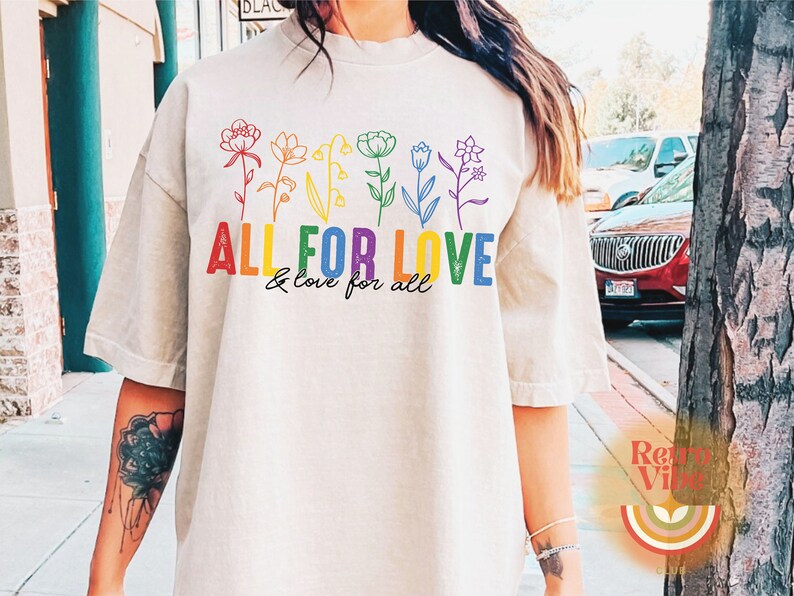 Puede incluir: Una camiseta blanca con un dise&ntilde;o de arco&iacute;ris de flores y el texto "ALL FOR LOVE & love for all".