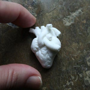 Può includere: Una tazza in ceramica fatta a mano con una glassa screziata color crema. La tazza presenta un corpo ampio e arrotondato e un manico robusto. L'interno è di una tonalità più scura e terrosa.