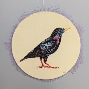 May include: A colorful, patterned bird with a long beak is depicted on a cream-colored circular canvas. The bird is surrounded by a purple, decorative border.