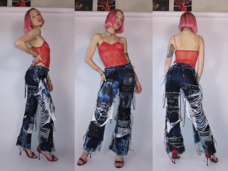 May include: Dark wash denim jeans with patchwork and distressed details. The jeans feature multiple fabric patches, white fringe, and black leather accents. The model is wearing a red lace top and red heels.