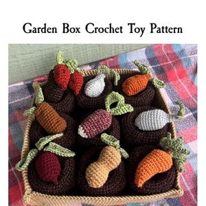 Puede incluir: Un patrón de juguete de caja de jardín de ganchillo con una variedad de verduras, incluyendo zanahorias, rábanos, nabos y un cacahuete. El patrón es de lowerrymade9048.