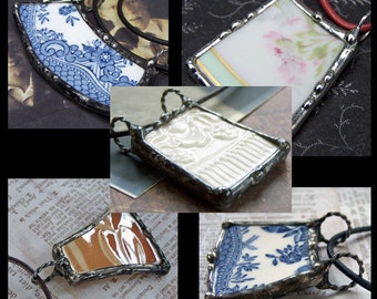 May include: Five different vintage porcelain pendants with silver-toned metal frames. Each pendant features a unique design, including floral patterns, a white embossed design, and blue and white patterns.