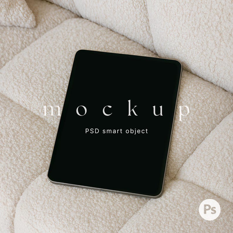 May include: A black tablet computer with a white "MOCKUP" text overlay and the words "PSD smart object" displayed on a white fluffy surface.