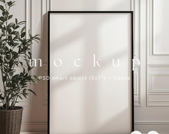 May include: A black framed poster mockup leaning against a white wall. The poster is blank, with the word "mockup" in white text. A potted plant with green leaves sits to the left. The text "PSD smart object (5x7") + Canva" is below the word "mockup".