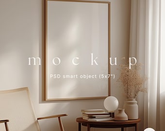 May include: A mockup of a framed poster in a living room setting. The poster is 5x7 inches and is in a wooden frame. The room is decorated in a minimalist style with a wooden chair, a side table, and a vase of dried flowers.