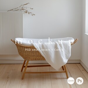 May include: A white wicker bassinet with a white blanket draped over the side. The bassinet is sitting on a wooden floor. The text "PSD smart object + Canva" is visible on the blanket.