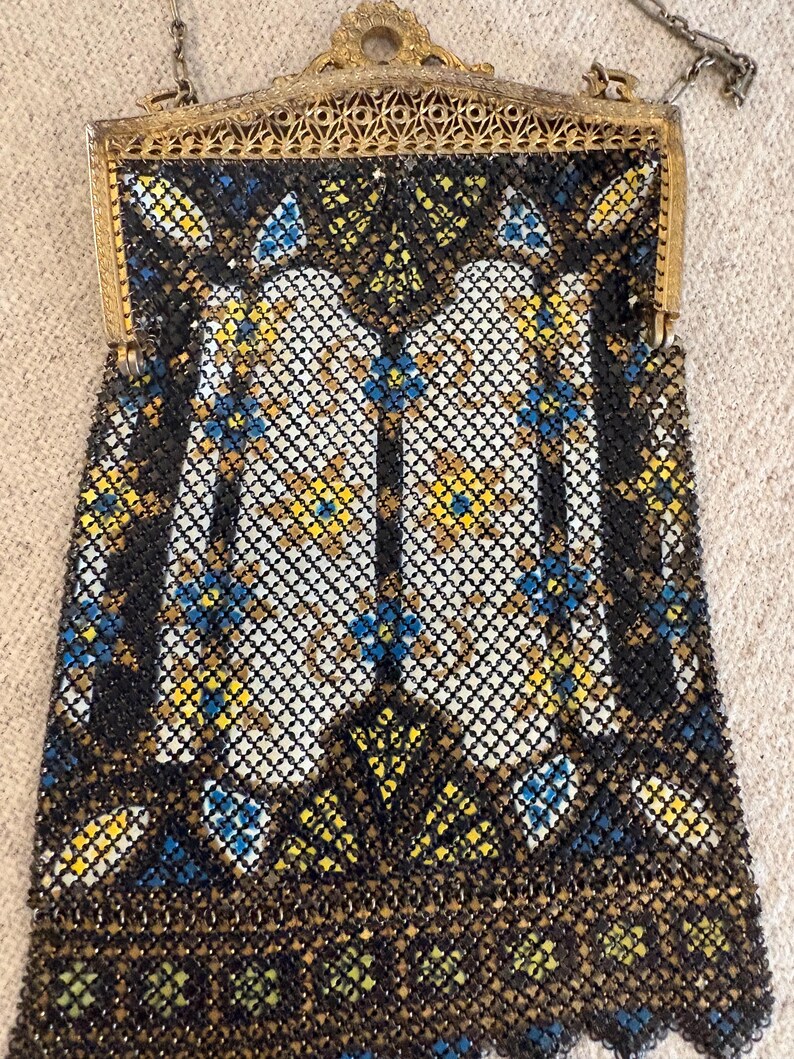May include: An antique beaded handbag with a gold-toned frame and chain. The bag features a geometric pattern in black, white, yellow, and blue beads. The frame has an ornate design.